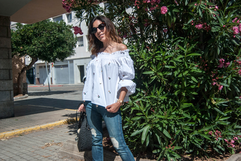 Camisa blanca de Zara con bordados de flores y hombros decubiertos. Jeans de Zara de tiro alto con efecto desgastado. Zapatillas de esparto y bolso de Zara. Zara white shirt with flower embroidery and covered shoulders. Zara jeans with worn effect. Esparto slippers and Zara handbag.