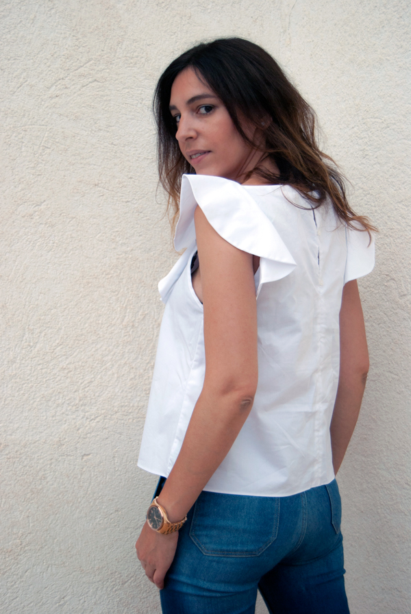 Camisa blanca de algodón con volante en el escote de Zara, complementado con jeans acampanados y sandalias de Zara. White cotton shirt with ruffle on the neckline of Zara, complemented by flared jeans and Zara sandals.