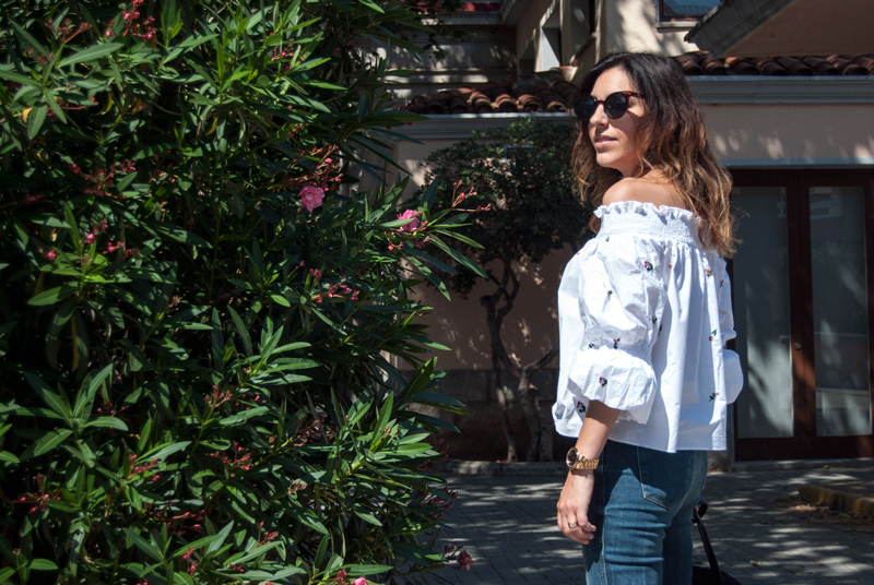 Camisa blanca de Zara con bordados de flores y hombros decubiertos. Jeans de Zara de tiro alto con efecto desgastado. Zapatillas de esparto y bolso de Zara. Zara white shirt with flower embroidery and covered shoulders. Zara jeans with worn effect. Esparto slippers and Zara handbag.