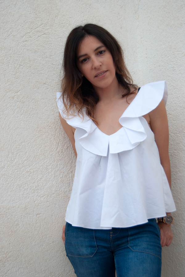 Camisa blanca de algodón con volante en el escote de Zara, complementado con jeans acampanados y sandalias de Zara. White cotton shirt with ruffle on the neckline of Zara, complemented by flared jeans and Zara sandals.